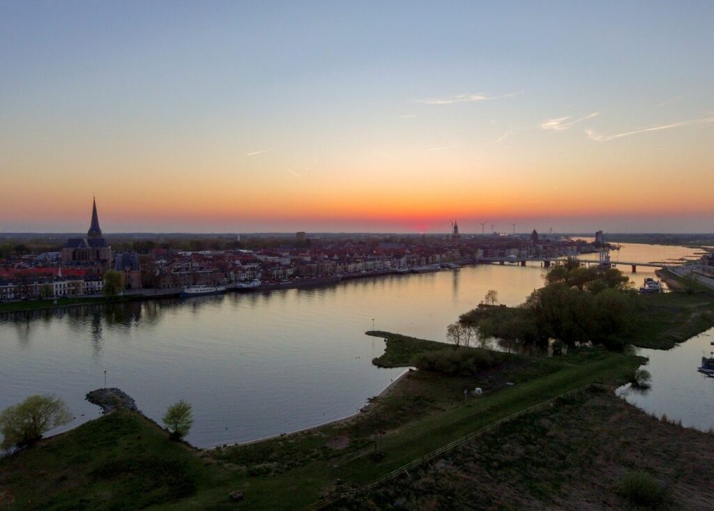 Luchtfoto van Kampen aan de IJssel bij zonsondergang, met de stadsbrug en de skyline van de oude stad