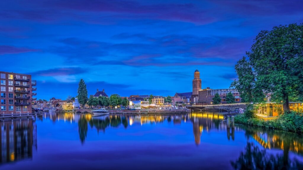 Zwolle in het blauwe uur, met de Peperbus en verlichte gebouwen die weerspiegelen in het water